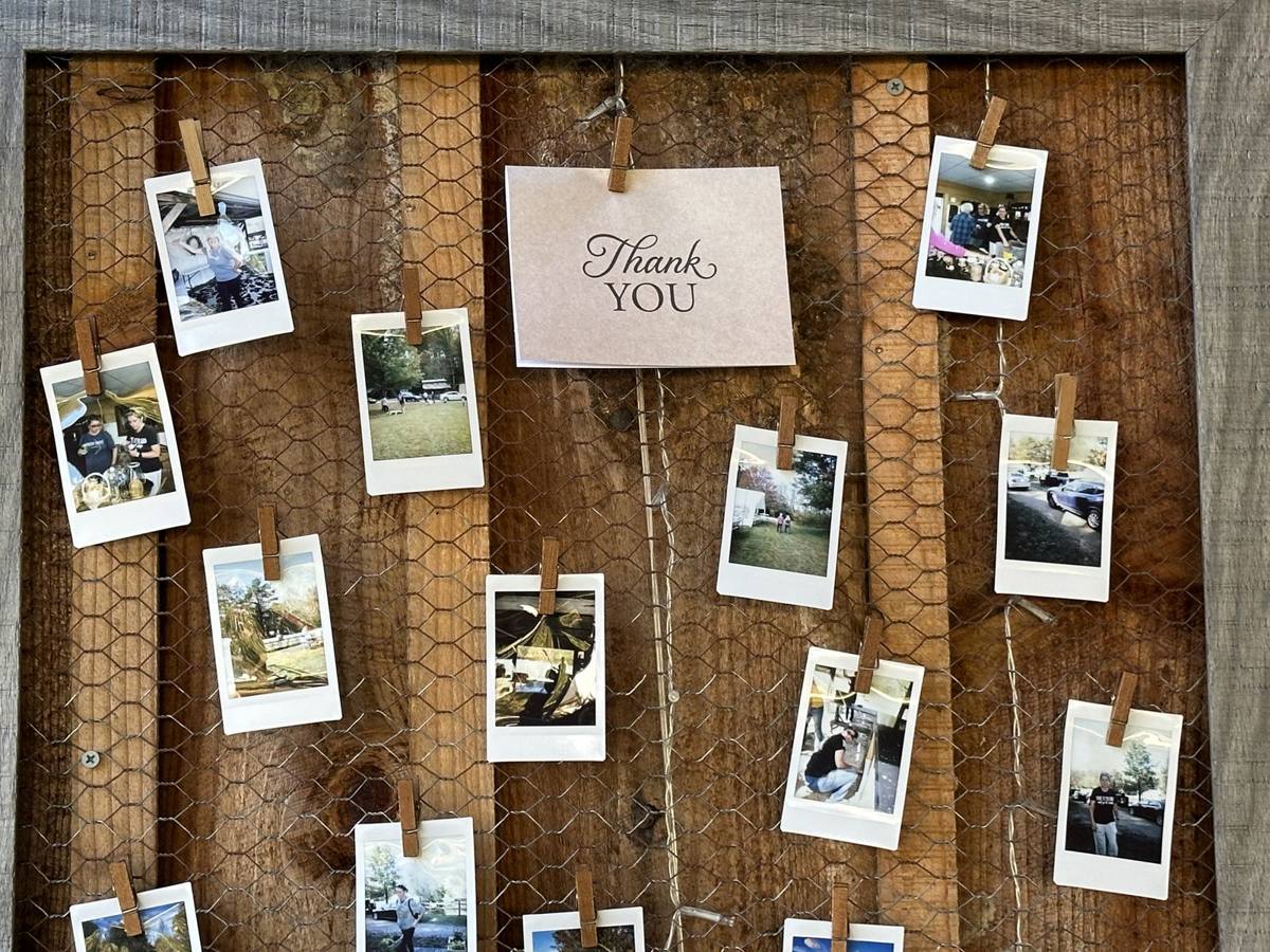Close-up of instant photos held with mini clothespins on chicken wire around a Thank YOU card