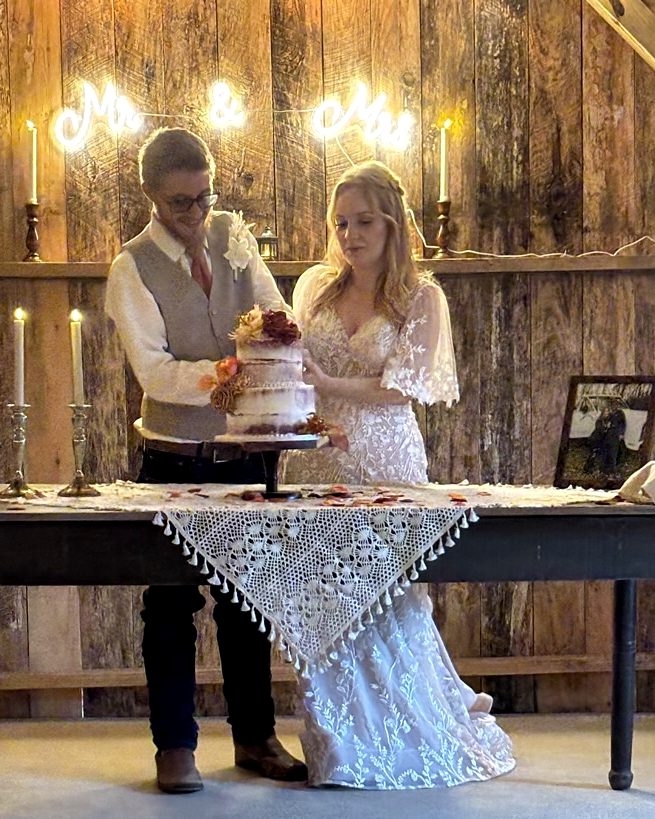 Couple cutting their cake in the barn at Riverside Farm Venue