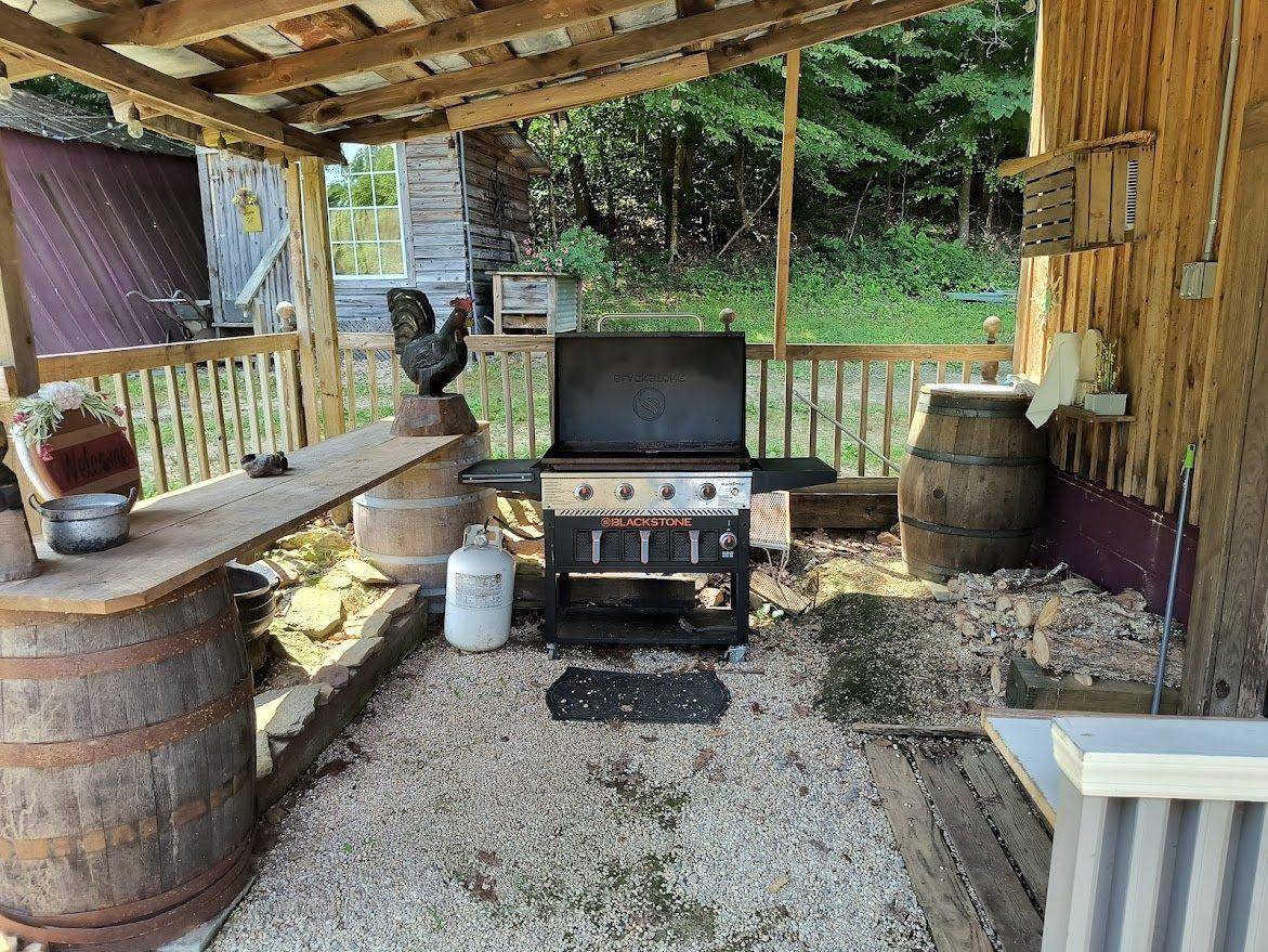 The covered grill area with a gas grill beside the tap room at Riverside Farm Venue