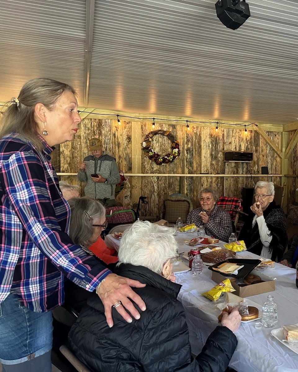 Family and friends gathered around a lunch table in the barn at Riverside Farm Venue